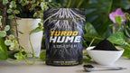 Turbo Hume worm casting fertilizer package with plants and soil in the background