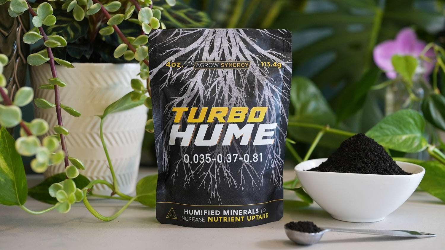 Turbo Hume worm casting fertilizer package with plants and soil in the background