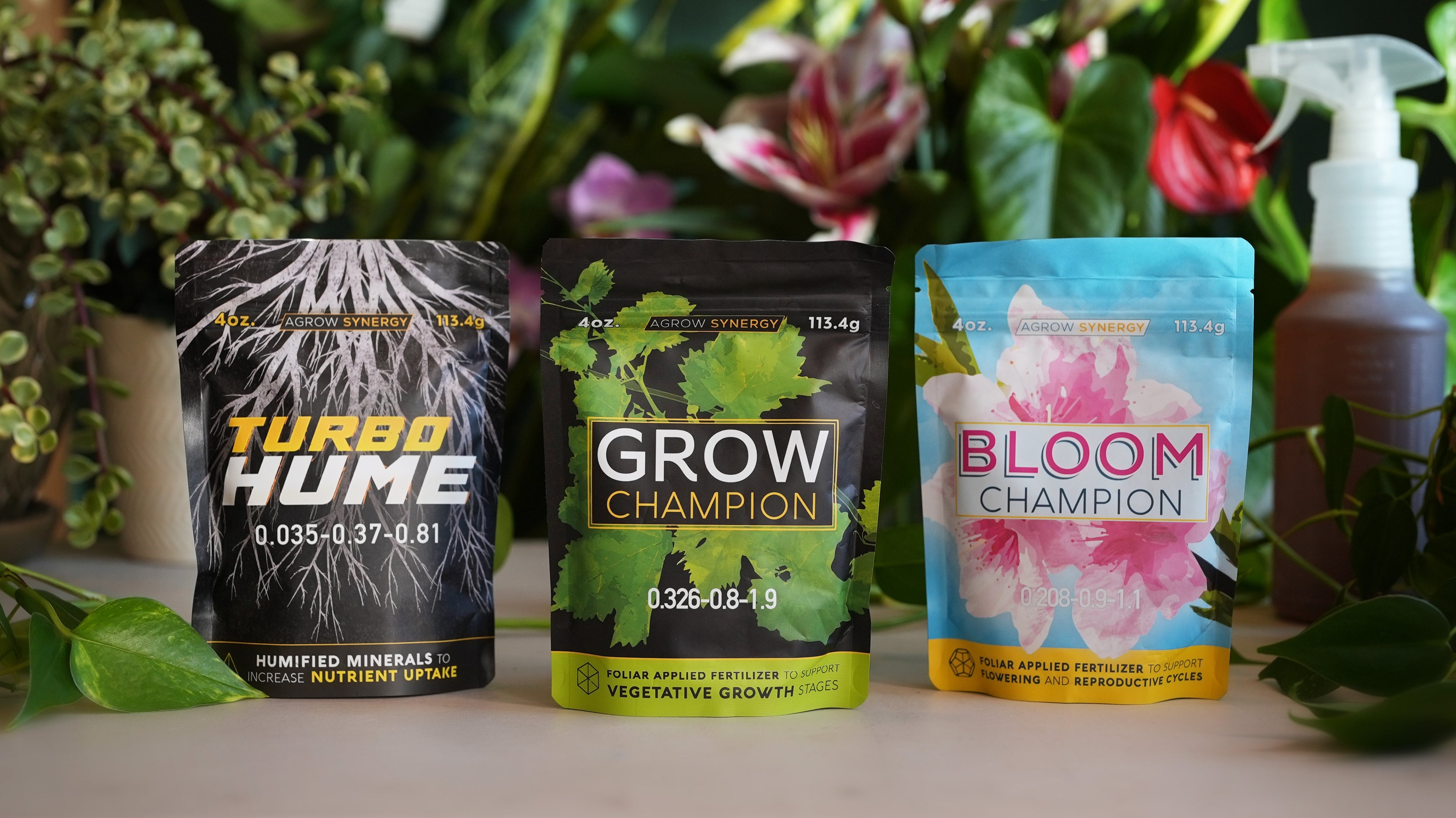 All natural fertilizer packages labeled 'Turbo Hume', 'Grow Champion', and 'Bloom Champion' with a spray bottle on a plant-themed background.
